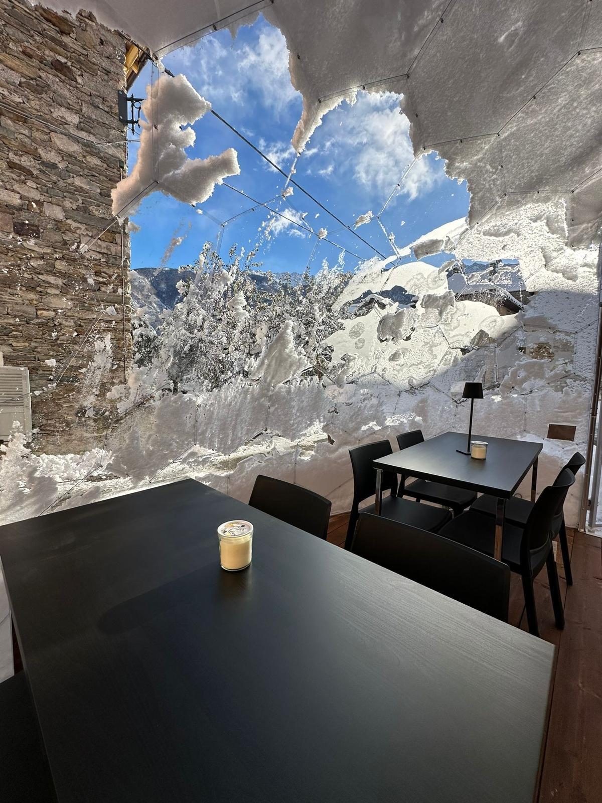 Tavola apparecchiata dentro la bolla trasparente mentre fuori nevica