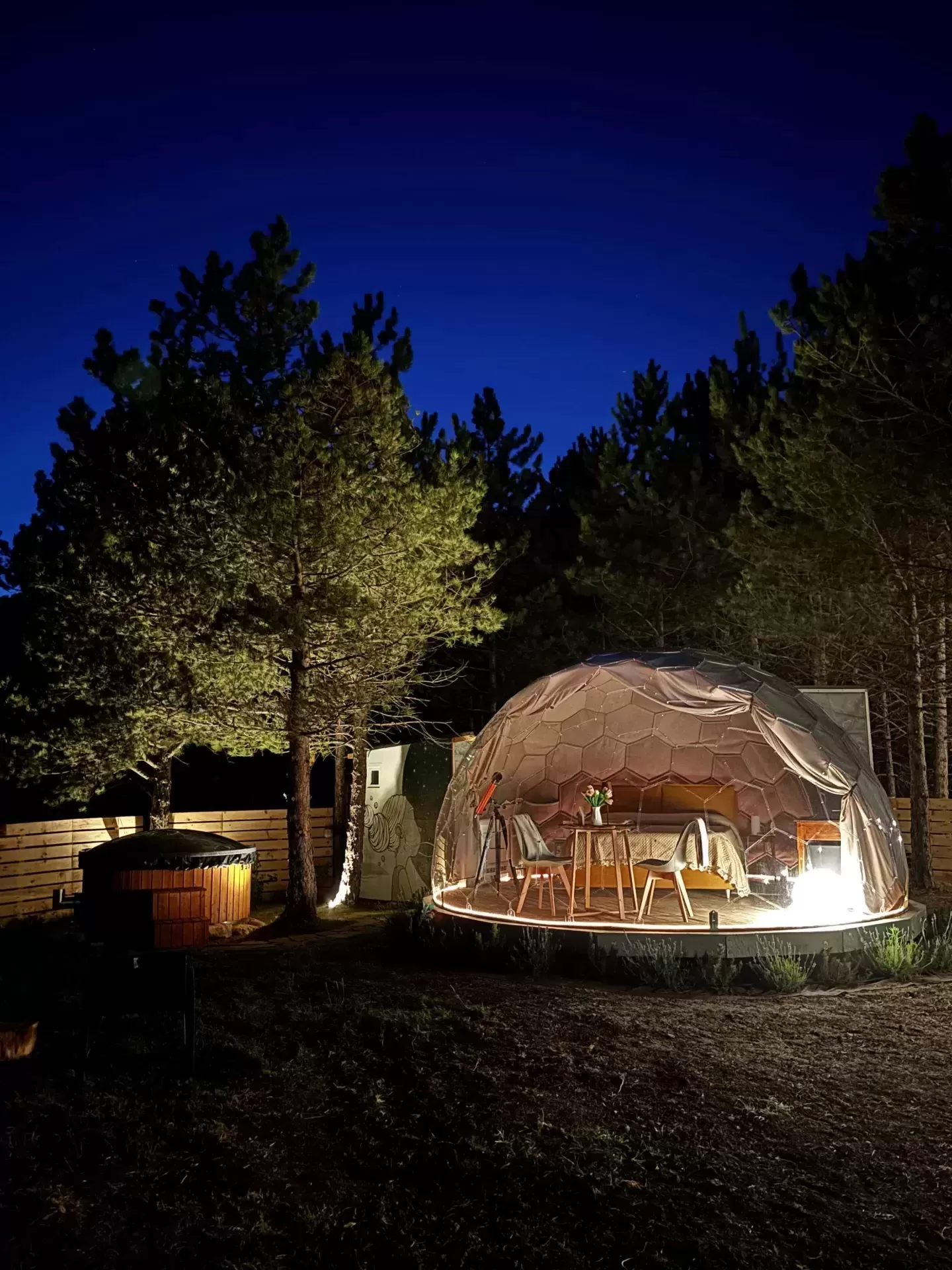 Bolla illuminata di notte con letto e vasca idromassaggio